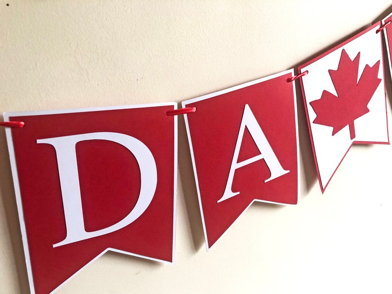 May include: Red and white banner with the word "CANADA" in white letters and a red maple leaf.