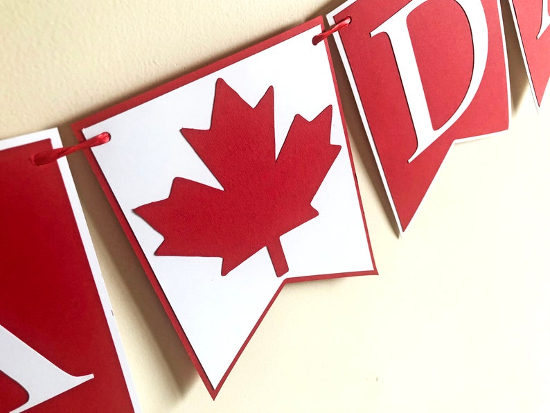 May include: Red and white paper banner with the word "Canada" and a red maple leaf.