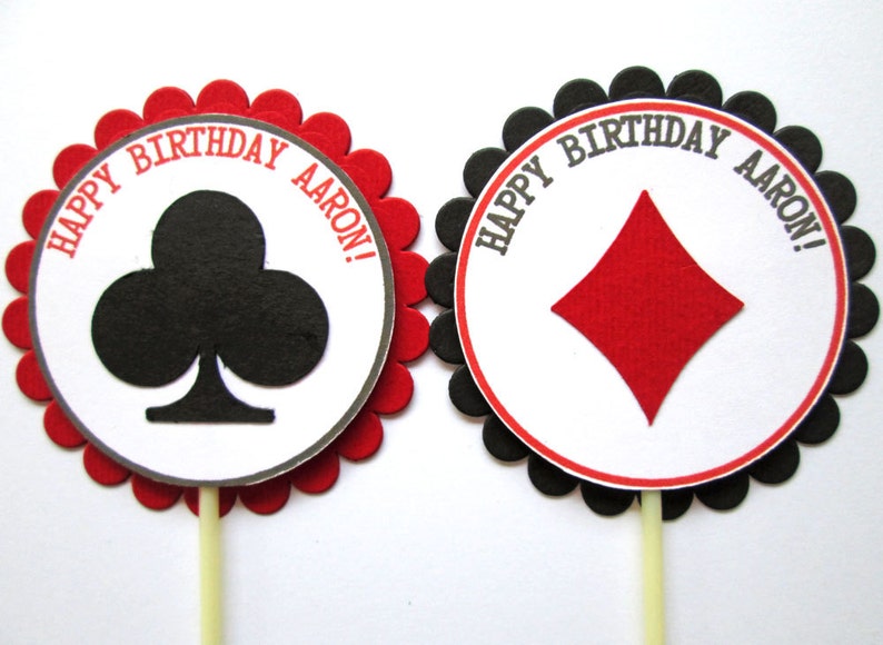 Peut inclure: Deux d&eacute;corations rondes pour cupcakes avec des bords festonn&eacute;s rouges et noirs. Les d&eacute;corations pr&eacute;sentent un cercle blanc avec du texte noir qui dit "Happy Birthday Aaron!" et un tr&egrave;fle noir ou un carreau rouge au centre.