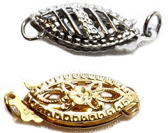 May include: Two ornate jewelry clasps. One is silver-toned with a filigree design, and the other is gold-toned with a similar pattern. Both clasps have a hook and eye closure, and are designed to secure necklaces or bracelets.