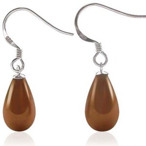 May include: A pair of silver-tone drop earrings with teardrop-shaped, brown-colored pendants. The earrings have a simple hook design and are displayed against a white background. The earrings are a classic jewelry accessory.