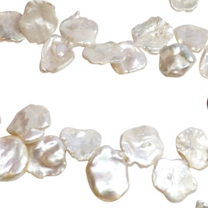 May include: Close-up of irregularly shaped, luminous white pearls. The pearls have a lustrous, iridescent sheen, reflecting light with a soft glow. The organic forms of the pearls are scattered against a white background, suggesting jewelry components or loose beads.