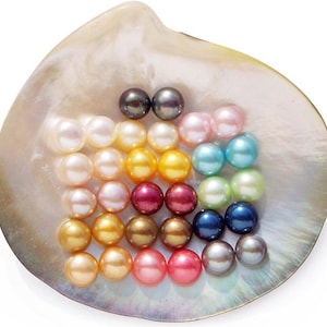 May include: A collection of colorful pearls in various shades, including white, pink, yellow, and blue, are arranged inside a large, iridescent seashell. The pearls are round and have a lustrous sheen, creating a visually appealing display.
