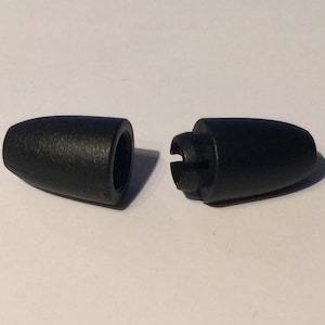 Puede incluir: Dos tapones de extremo de cord&oacute;n de pl&aacute;stico negro, uno con un agujero y el otro con un clip.