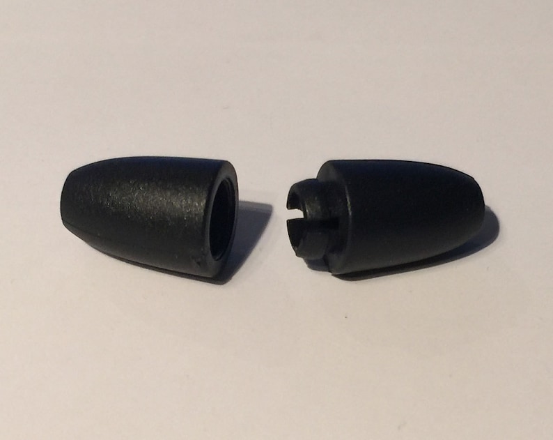 Puede incluir: Dos tapones de extremo de cord&oacute;n de pl&aacute;stico negro, uno con un agujero y el otro con un clip.