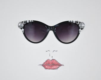 Black Designer fashion cat-eye sunglasses embellished with crystal rhinestone jewels and silvertone accents.