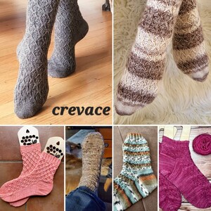 May include: A collection of five pairs of hand-knitted socks in various colors and patterns, including brown, white, pink, and blue. The socks are displayed on a variety of surfaces, including wood and fabric.