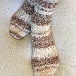 May include: A pair of brown and cream striped knitted socks with a cable knit pattern.
