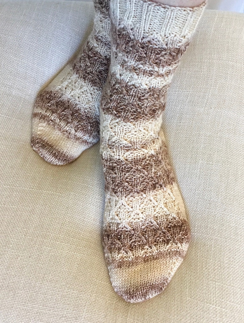 May include: A pair of brown and cream striped knitted socks with a cable knit pattern.