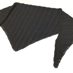 K&ouml;nnte beinhalten: Ein schwarzer gestrickter Schal mit dreieckiger Form und einem strukturierten Muster.