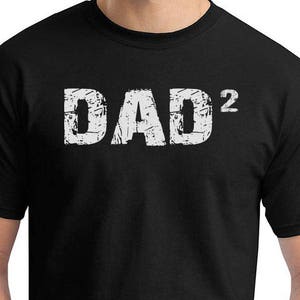 May include: Black t-shirt with white text that reads "DAD^2".