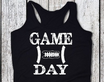 May include: Black tank top with a white graphic that says "GAME DAY" with a football in the middle of the word "GAME".