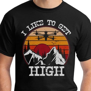 May include: Black t-shirt with a retro-style graphic of a drone flying over mountains with the text "I Like To Get High".