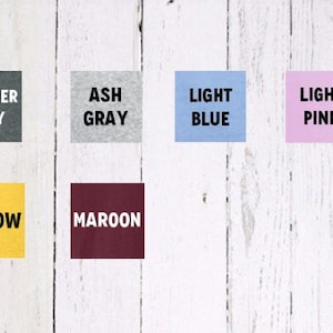 May include: Color swatches for t-shirts in heather gray, ash gray, light blue, light pink, yellow, and maroon.