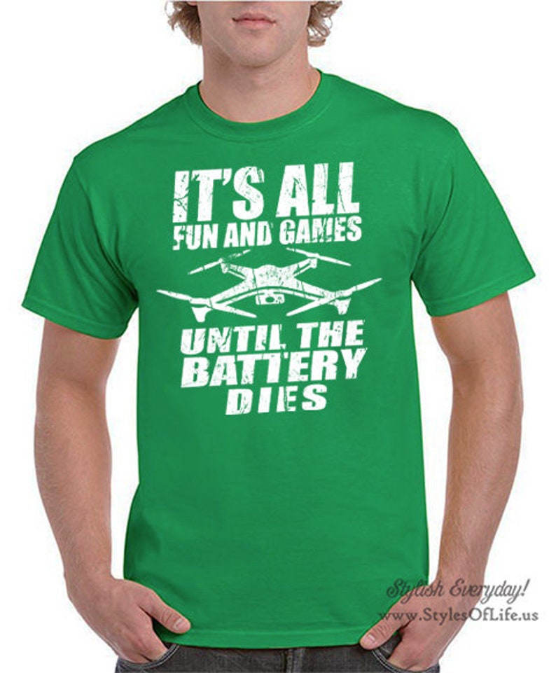 May include: Green t-shirt with a white graphic of a drone and the text "It's all fun and games until the battery dies."