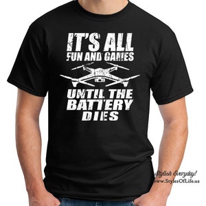 May include: Black t-shirt with white text that reads "It's all fun and games until the battery dies." A white silhouette of a drone is above the text.