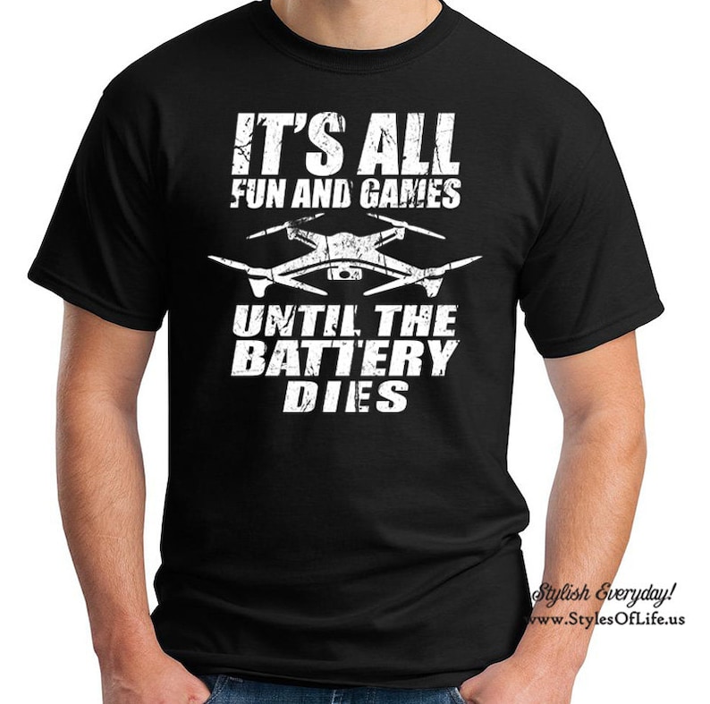 May include: Black t-shirt with white text that reads "It's all fun and games until the battery dies." A white silhouette of a drone is above the text.