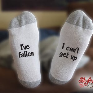 May include: A pair of white socks with gray trim. One sock says "I've fallen" and the other says "I can't get up".