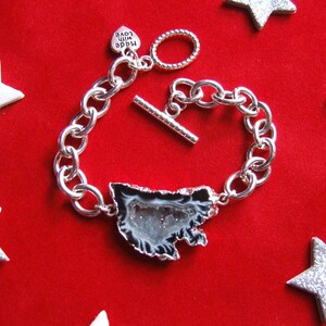May include: A silver chain bracelet with a silver toggle clasp and a heart-shaped charm that says "Made with Love". The bracelet features a large, clear agate stone pendant with a black and white pattern.