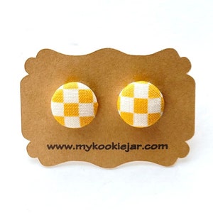 Puede incluir: Un par de pendientes de botón de tela a cuadros amarillos y blancos en una tarjeta marrón con el texto "www.mycookiejar.com".