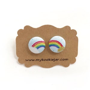 May include: A pair of rainbow button earrings on a brown card with the text "www.mycookiejar.com".