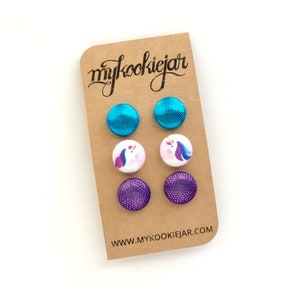 May include: A set of six stud earrings on a card with the text "mycookiejar" and "www.mycookiejar.com". The earrings are in three different designs: turquoise glitter, purple glitter, and white with a unicorn design.