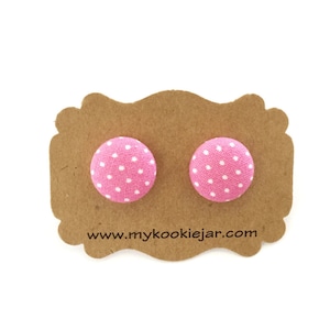 May include: A pair of pink fabric button earrings with white polka dots. The earrings are displayed on a brown card with the website address "www.mykookiejar.com".