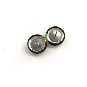 May include: A pair of brown fabric earrings with rainbow colored thread accents. The earrings have silver posts and backs.