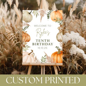 May include: A custom printed sign on an easel, featuring a watercolor design with pumpkins and foliage. The sign reads "Welcome to Rylee's Tenth Birthday 10.10.25". The bottom of the sign says "CUSTOM PRINTED".