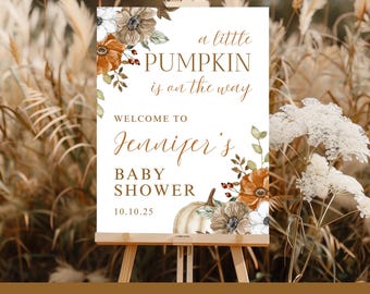 May include: A custom-printed baby shower sign on an easel. The sign features the text "a little PUMPKIN is on the way" and "WELCOME TO Jennifer's BABY SHOWER 10.10.25". The sign is decorated with floral and pumpkin illustrations.