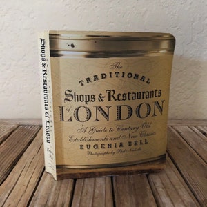May include: A book titled "The Traditional Shops & Restaurants of London: A Guide to Century Old Establishments and New Classics" by Eugenia Bell with photographs by Phil Nicholls.