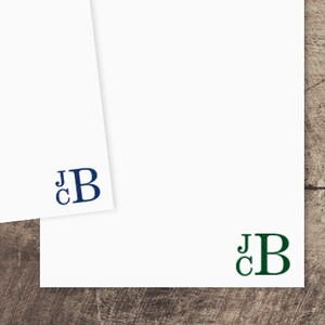 May include: Two blank stationery note cards with the initials "JCB" printed on them. The card on the left has the initials in navy blue, and the card on the right has the initials in dark green.