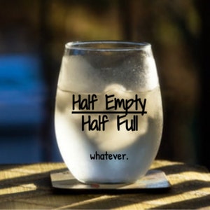 May include: A clear glass wine glass with the text "Half Empty Half Full whatever." printed on the side.