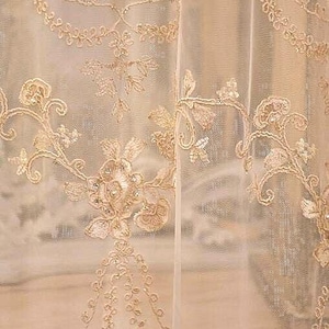 May include: A pair of sheer white curtains with delicate gold embroidery featuring floral patterns. The embroidery is intricate and detailed, creating a luxurious and elegant look.