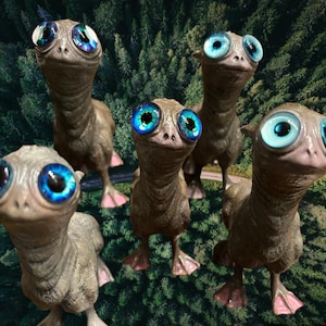 May include: Five small, grey, humanoid figures with large, blue eyes and wide smiles stand in a forest. They have long necks and small, bird-like feet.
