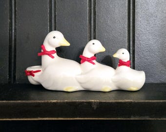 Enten oder Gänse in einer Reihe Kerzenhalter mit roten Schleifen