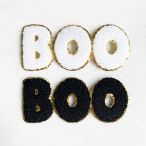 May include: White and black felt letters spelling "BOO BOO" with gold glitter trim.