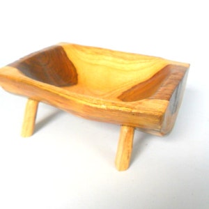 Puede incluir: Un cuenco de madera con un acabado de madera natural y un centro marr&oacute;n oscuro. El cuenco est&aacute; sobre cuatro patas cortas.