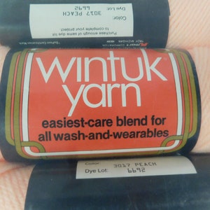 May include: A skein of peach-colored Wintuk yarn. The label reads "Wintuk yarn, easiest-care blend for all wash-and-wearables." The label also includes the color and dye lot information: "Color: 3017 PEACH, Dye Lot: 6692."