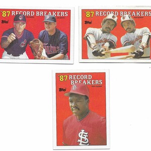 May include: Three Topps 87 Record Breakers baseball cards featuring Phil Niekro, Joe Niekro, Eddie Murray, and Vince Coleman. Each card has a bright red background with white text and the Topps logo. The cards display professional baseball players.