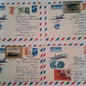 May include: Four vintage airmail envelopes with stamps and handwritten addresses. Each envelope features a red, white, and blue striped border and a stylized airplane graphic. The stamps depict landscapes and historical scenes.