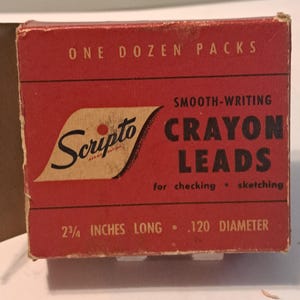 May include: A red box with white lettering that reads "ONE DOZEN PACKS" and "SMOOTH-WRITING CRAYON LEADS for checking • sketching". The box also says "Scripto" and "2 3/4 INCHES LONG .120 DIAMETER".