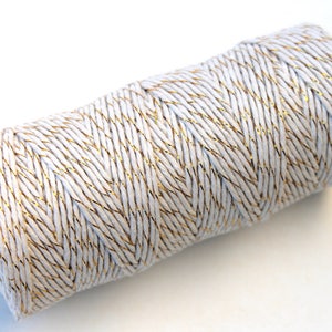 May include: A roll of white twine with gold metallic thread running through it.