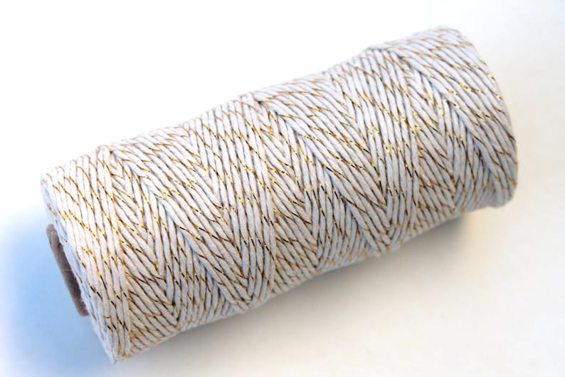 May include: A roll of white twine with gold metallic thread running through it.