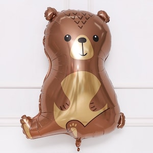 May include: A brown and gold foil balloon shaped like a bear. The bear has a cute cartoon face with black eyes, a black nose, and a black smile.