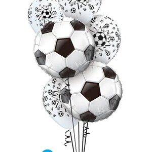 May include: A bouquet of six black and white soccer-themed balloons. The balloons feature a soccer ball design and the text "Qualatex The Very Best Balloons qualatex.com".