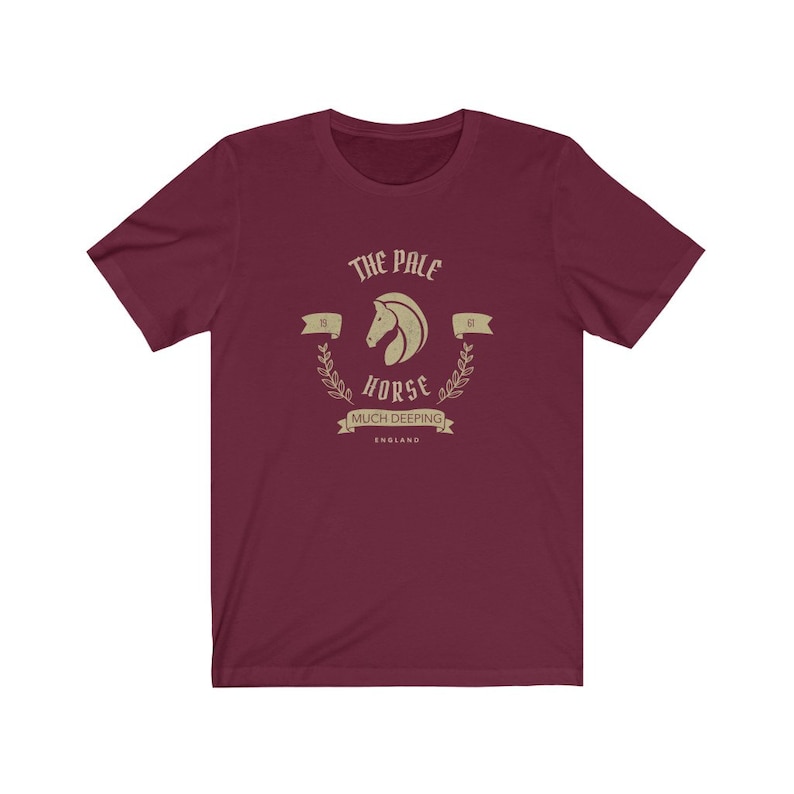K&ouml;nnte beinhalten: Ein maroonfarbenes T-Shirt mit einer Vintage-Grafik eines Pferdekopfes mit dem Text "The Pale Horse", "15", "of", "Horse", "Much Deeping" und "England".