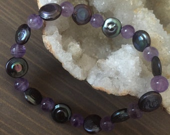 May include: A bracelet made with alternating amethyst and iridescent black beads.