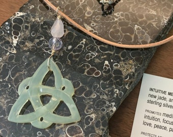 May include: A green jade Celtic knot pendant necklace with amethyst and rose quartz beads on a brown leather cord. The necklace is designed to promote meditation, clarity, creativity, intuition, focus, balance, enlightenment, love, peace, patience, cleansing, and to protect against emotional chaos, depression, and negative energy.  WWW.TRACYKREIFELSART.COM WEARABLE HEALING ART