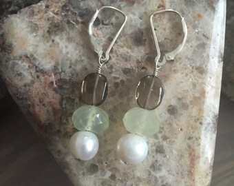 May include: Silver dangle earrings with three beads each. The top bead is smoky quartz, the middle bead is green aventurine, and the bottom bead is a white pearl.